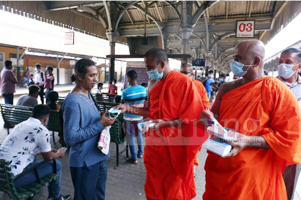 Buddhist monks distributing medical masks.
